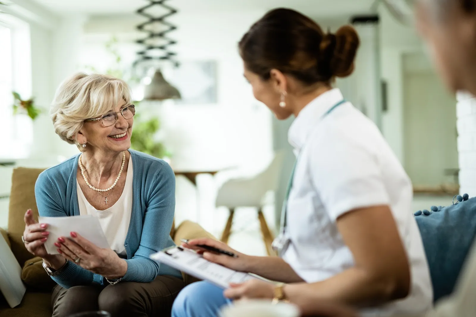 happy-mature-woman-communicating-with-female-doctor-home