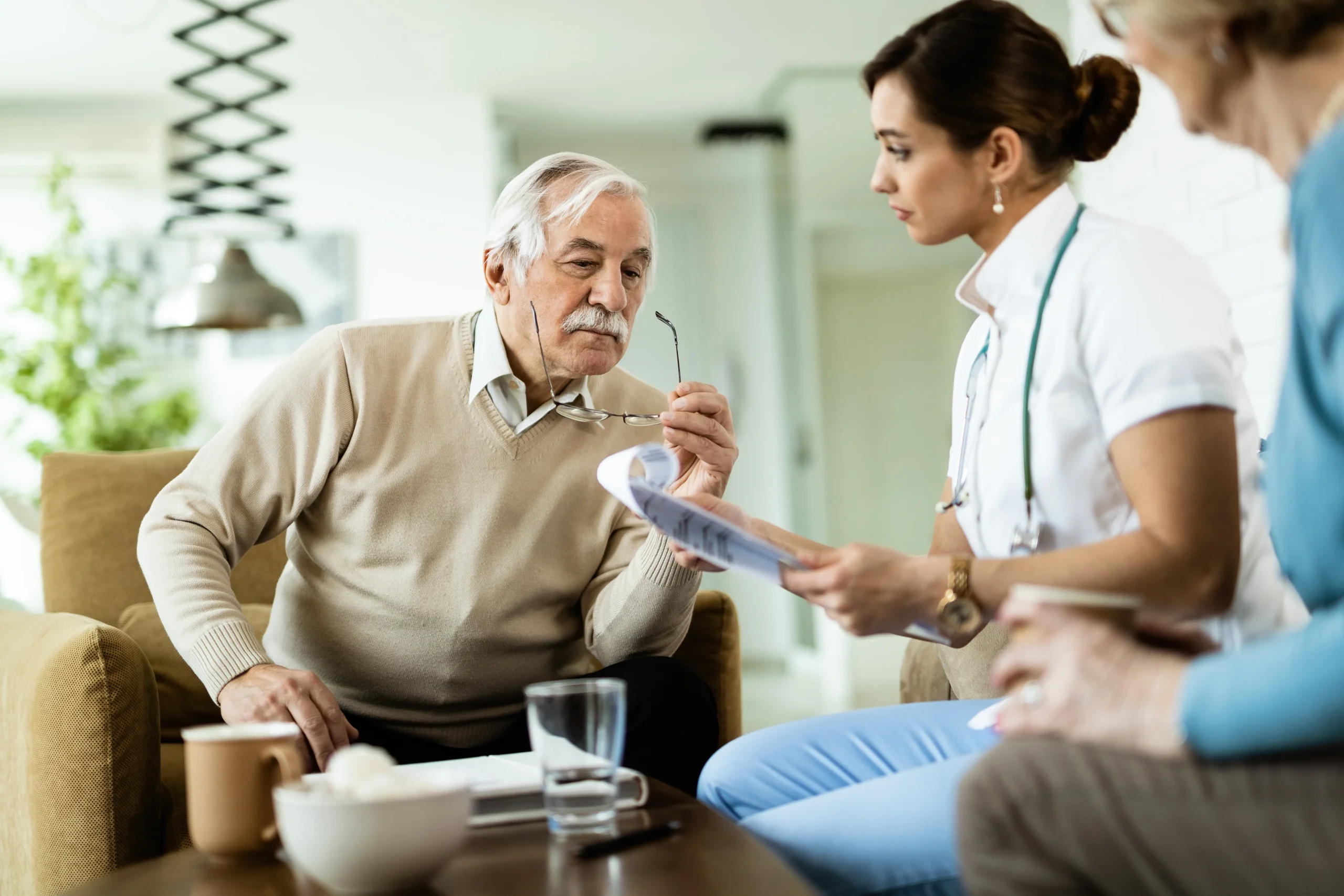 senior-man-healthcare-worker-going-through-medical-reports-during-home-visit